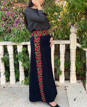 girl wearing a black embroidered maxi skirt with red floral embroidery